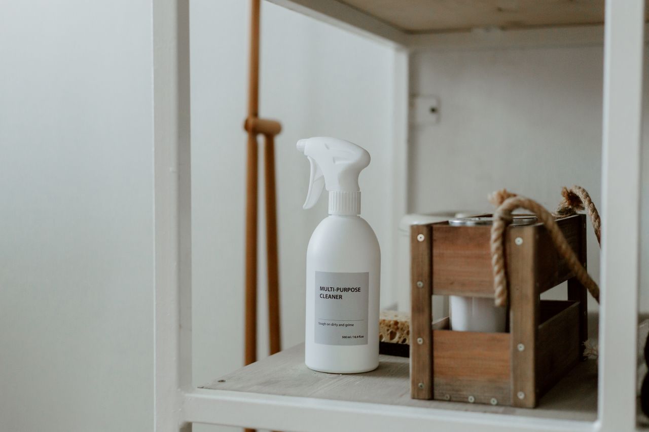 Services-01 Clean white shelf with a spray cleaner and wooden caddy, perfect for home organization.